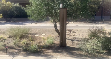 An approximately 4 foot tall skinny box with brown slats and some sensors on the top