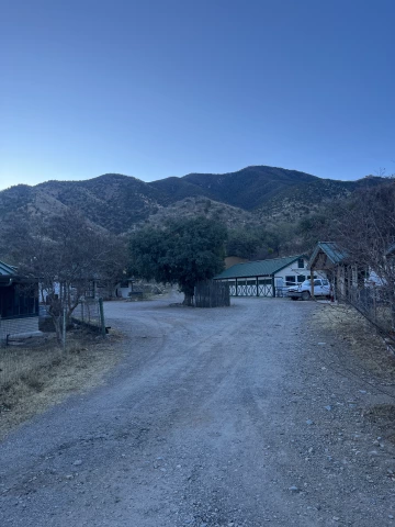 Photo of a building and truck before desert mountains