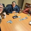 3 people sitting around a table playing a board game